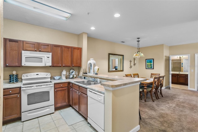 kitchen with kitchen peninsula, sink, light colored carpet, and white appliances