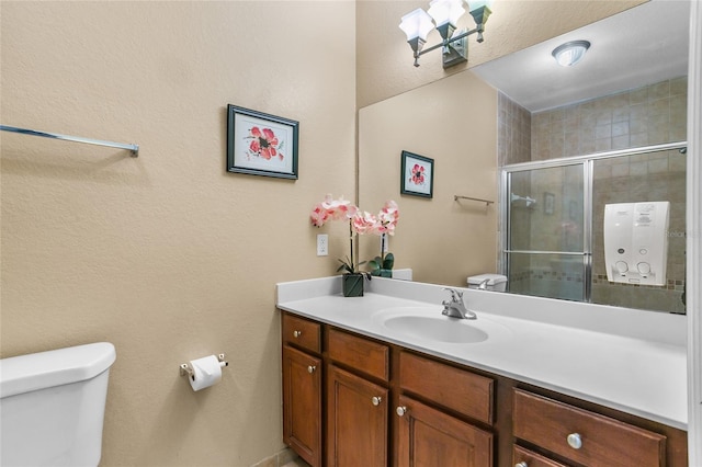 bathroom with vanity, toilet, and a shower with shower door