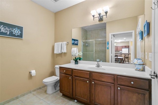 bathroom with toilet, vanity, tile patterned floors, and a shower with shower door