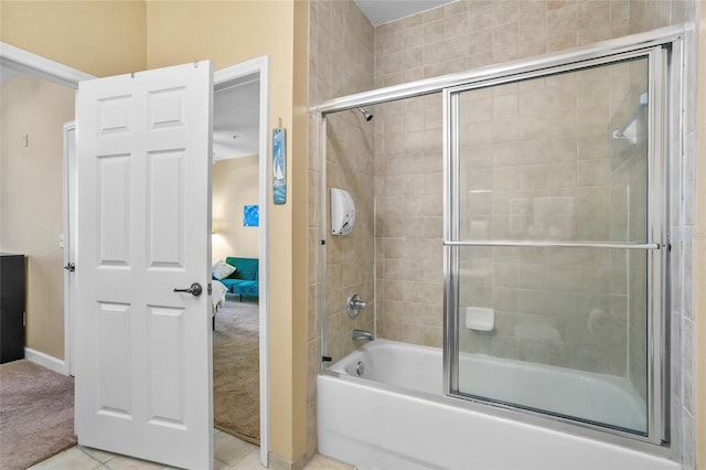 bathroom featuring tile patterned flooring and bath / shower combo with glass door