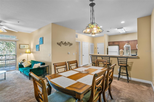 dining room featuring ceiling fan and light colored carpet