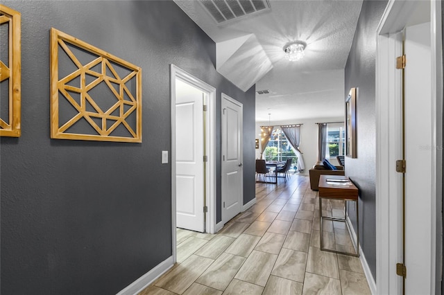 hallway featuring a chandelier and light hardwood / wood-style floors