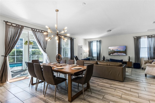 dining room featuring light wood-type flooring and an inviting chandelier