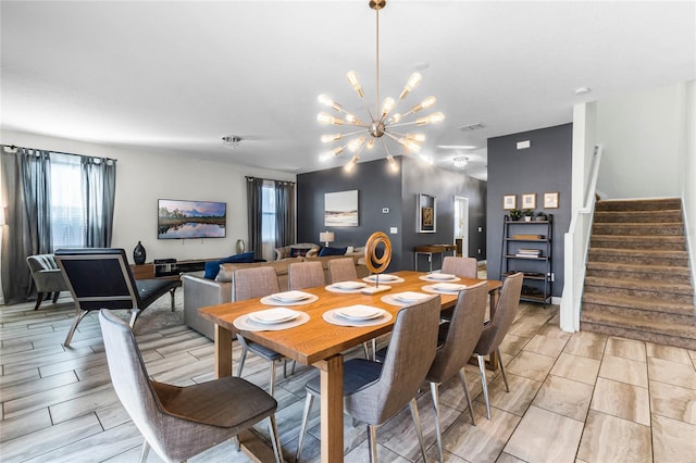 dining space with light hardwood / wood-style flooring and an inviting chandelier