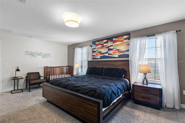 bedroom featuring multiple windows, carpet floors, and a textured ceiling