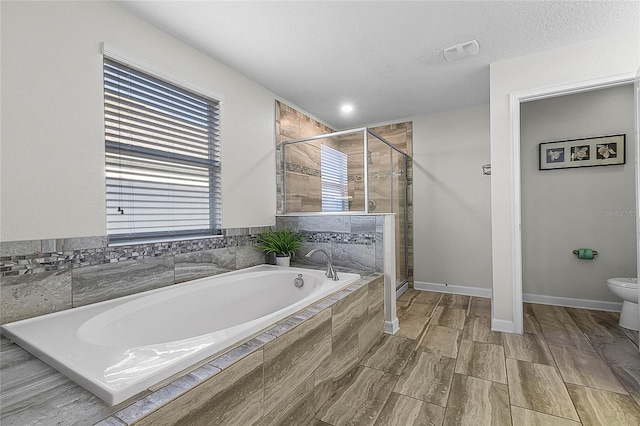 bathroom featuring shower with separate bathtub, a textured ceiling, and toilet