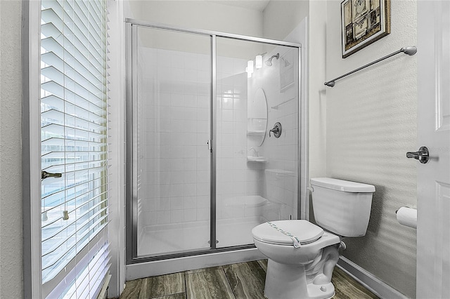 bathroom with toilet, wood-type flooring, and walk in shower