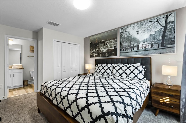 carpeted bedroom featuring ensuite bathroom and a closet