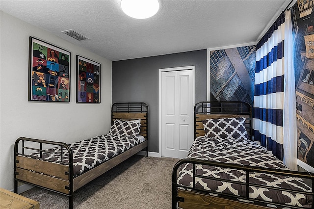 bedroom with carpet, a textured ceiling, and a closet