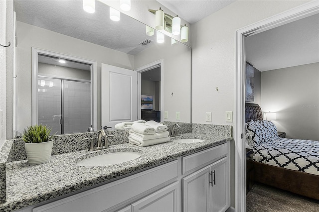 bathroom with vanity, a shower with door, and a textured ceiling