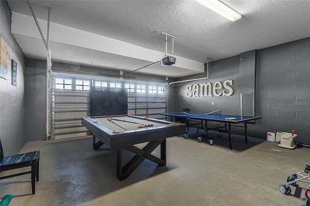 playroom with concrete flooring, a textured ceiling, and billiards