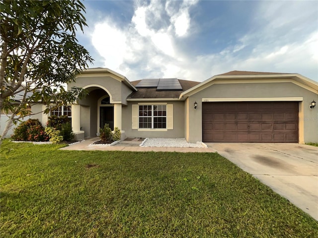 view of front of home featuring a front lawn, a garage, and solar panels