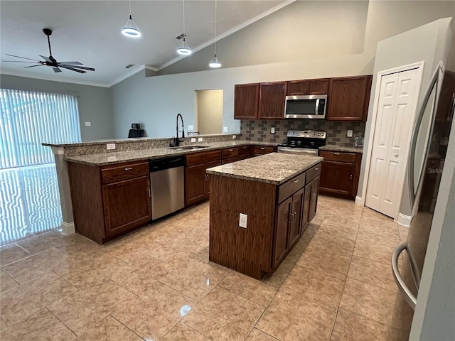 kitchen featuring sink, a center island, pendant lighting, lofted ceiling, and appliances with stainless steel finishes