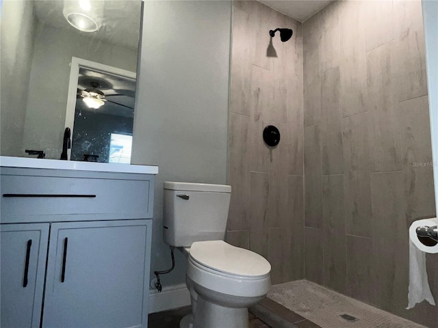 bathroom featuring tiled shower, vanity, and toilet