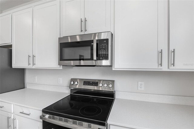 kitchen featuring white cabinets, stainless steel appliances, and light countertops