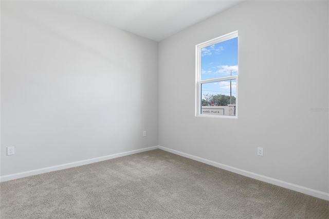 unfurnished room with carpet floors and baseboards