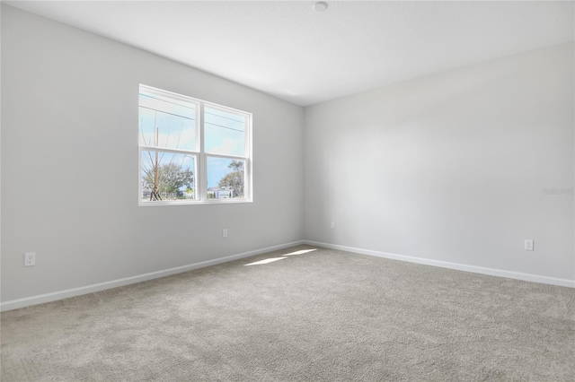 spare room with carpet and baseboards