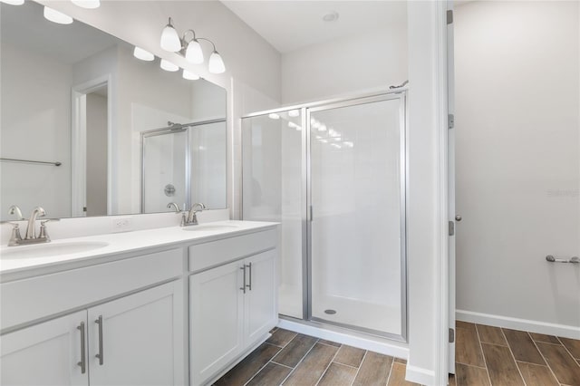 bathroom with wood tiled floor, a sink, and a shower stall