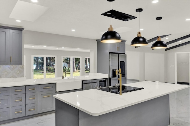 kitchen featuring decorative light fixtures, sink, appliances with stainless steel finishes, and tasteful backsplash