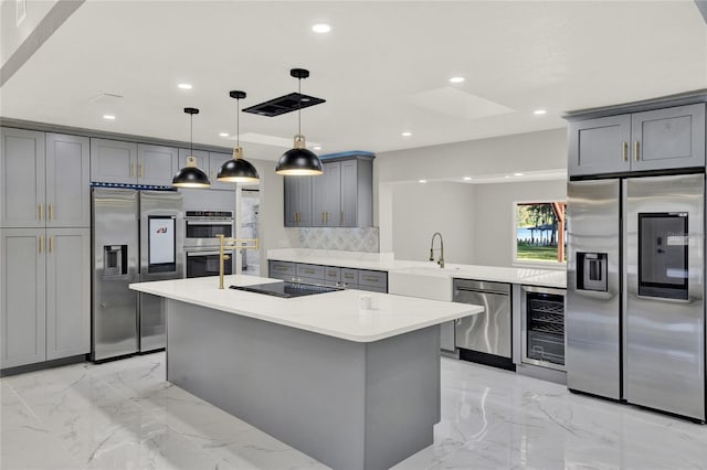 kitchen featuring gray cabinetry, sink, hanging light fixtures, stainless steel appliances, and wine cooler