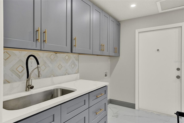 kitchen with decorative backsplash, gray cabinetry, and sink