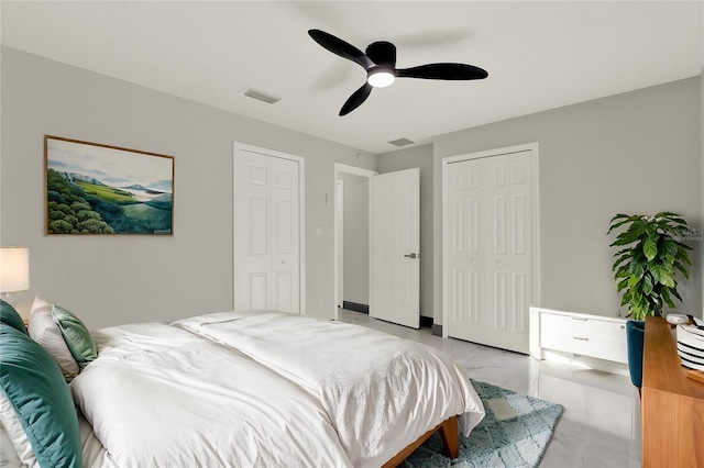 bedroom featuring ceiling fan and two closets