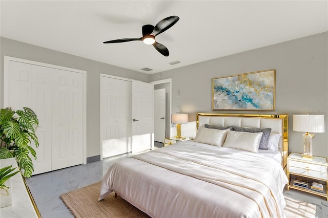 bedroom with ceiling fan and multiple closets