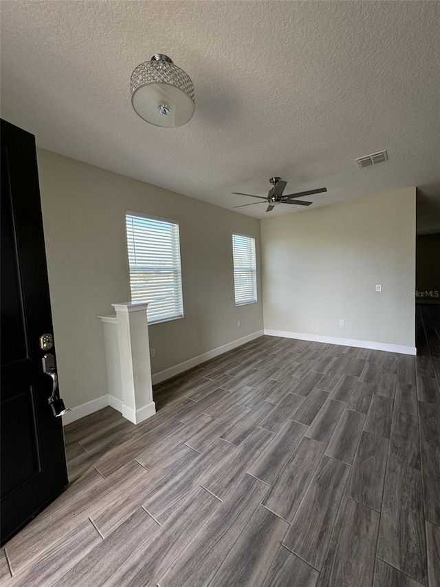 empty room featuring ceiling fan, a textured ceiling, and hardwood / wood-style flooring