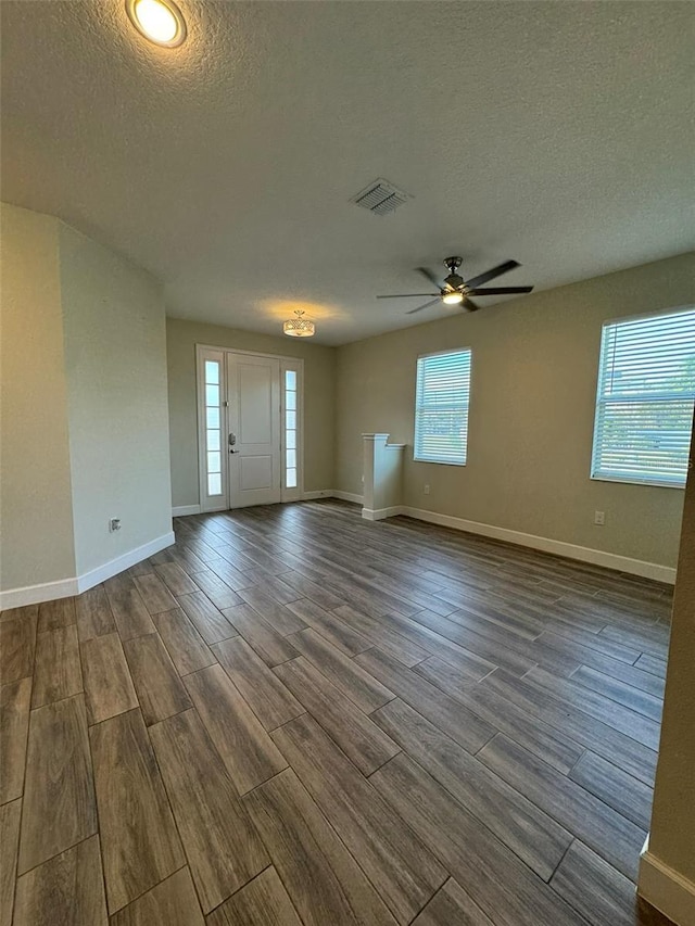 interior space with a wealth of natural light, ceiling fan, a textured ceiling, and hardwood / wood-style flooring