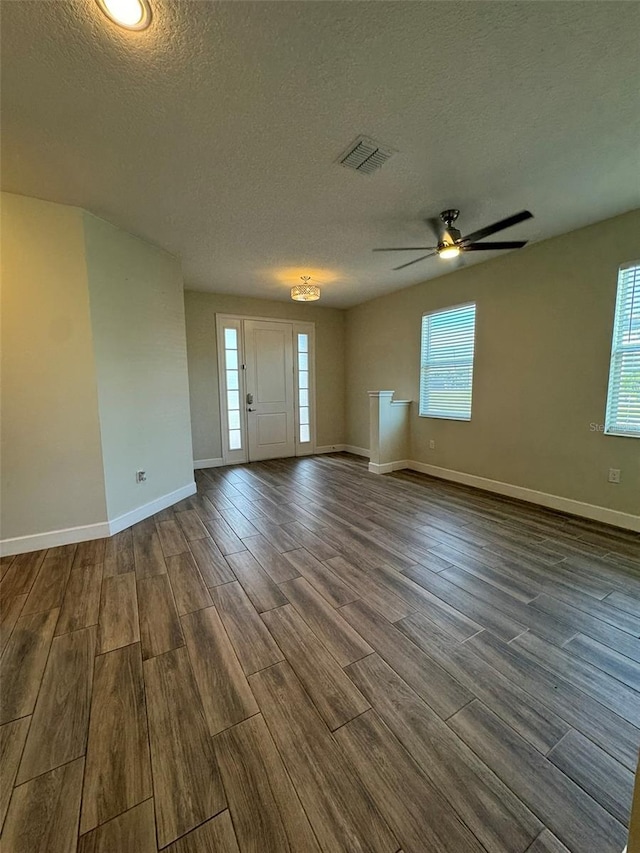 interior space with a wealth of natural light, hardwood / wood-style floors, ceiling fan, and a textured ceiling