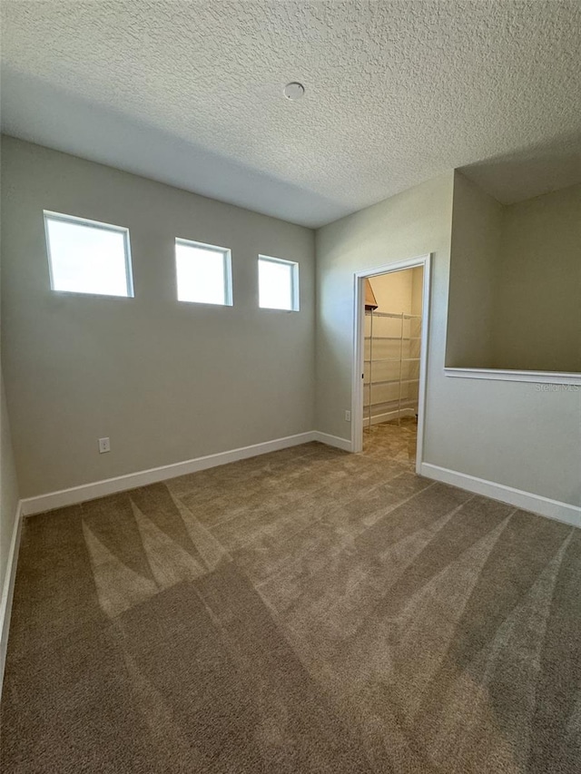 carpeted spare room with a textured ceiling