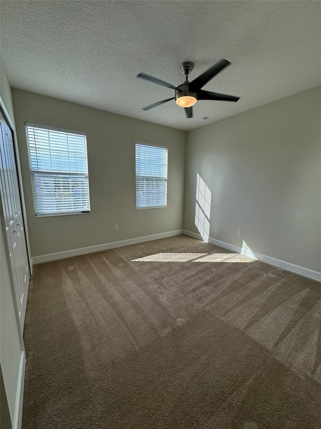 empty room with carpet flooring, a textured ceiling, and ceiling fan