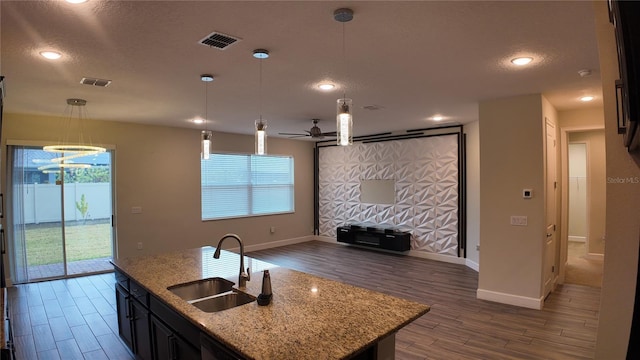 kitchen with visible vents, a sink, dark wood-type flooring, pendant lighting, and open floor plan