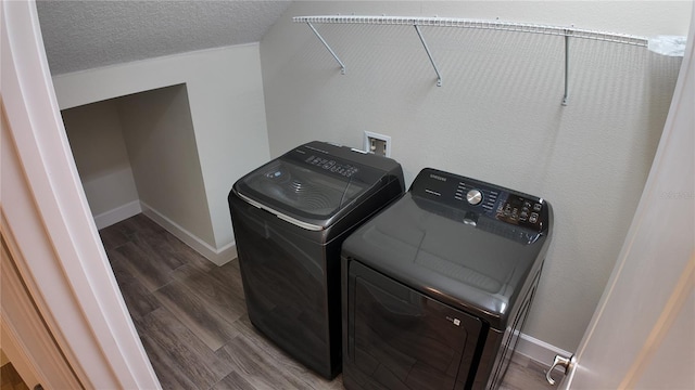 laundry room featuring a textured ceiling, wood finished floors, washing machine and dryer, and laundry area