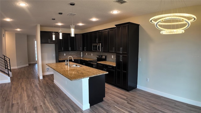 kitchen featuring backsplash, wood finished floors, appliances with stainless steel finishes, and a sink