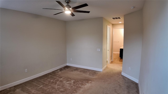 carpeted empty room featuring visible vents, baseboards, and a ceiling fan