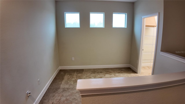 empty room with baseboards and carpet