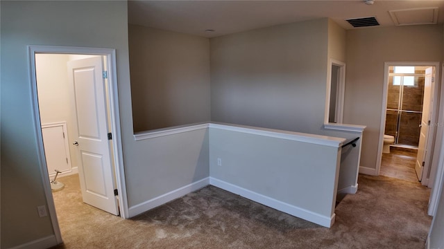 hallway featuring visible vents, an upstairs landing, baseboards, and carpet flooring