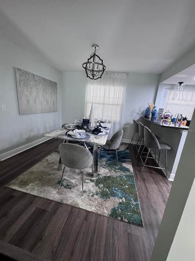 dining area featuring dark hardwood / wood-style floors and a chandelier