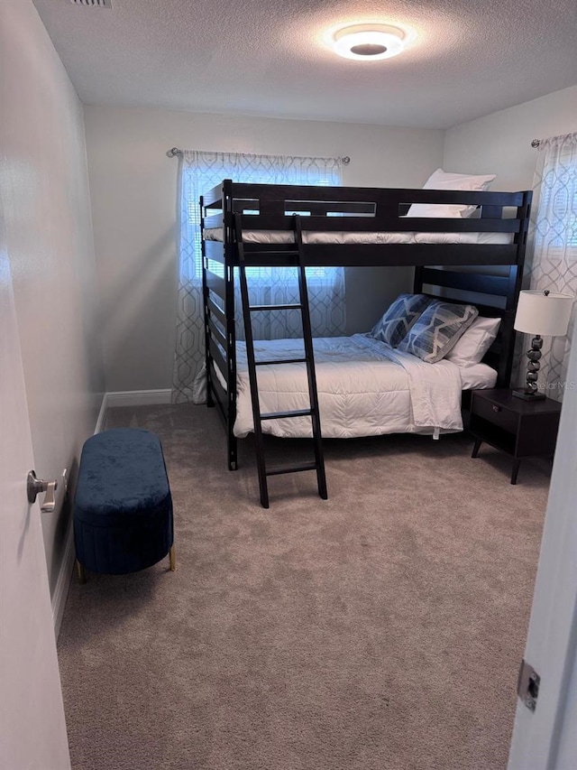 bedroom featuring carpet and a textured ceiling