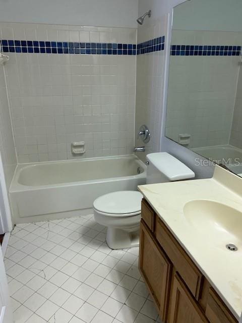 full bathroom featuring tile patterned flooring, vanity, toilet, and tiled shower / bath