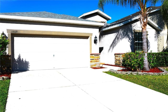 1569 Thetford Cir, Orlando, FL 32824 - view of front of home with stucco siding, an attached garage, and concrete driveway
