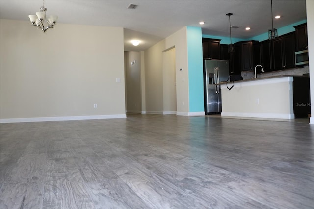 kitchen featuring hardwood / wood-style floors, a notable chandelier, decorative light fixtures, and appliances with stainless steel finishes