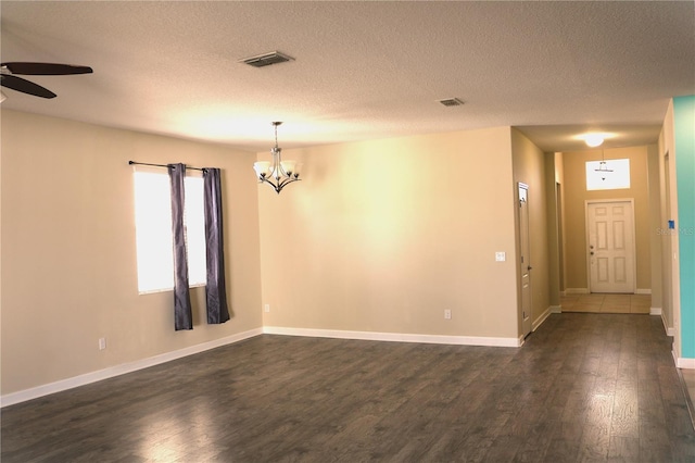 1569 Thetford Cir, Orlando, FL 32824 - empty room featuring a chandelier, ceiling fan, dark wood-style flooring, baseboards, and a textured ceiling