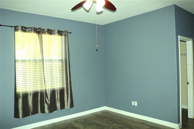 spare room with a textured ceiling, ceiling fan, and dark wood-type flooring