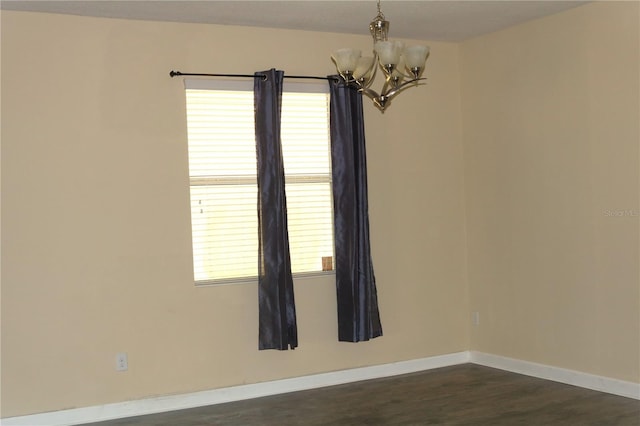 unfurnished room featuring dark wood-type flooring and a chandelier