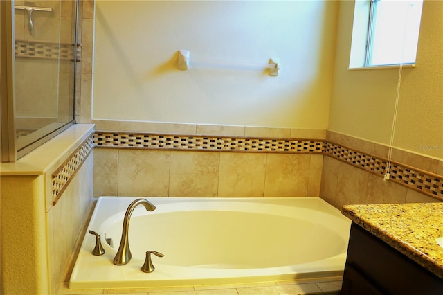 bathroom featuring vanity and a tub to relax in