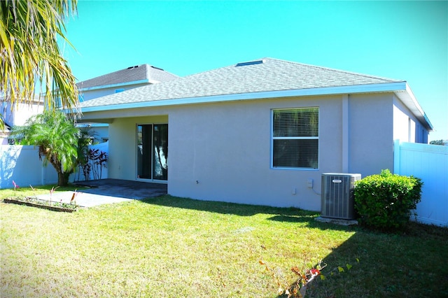 back of house featuring a lawn, cooling unit, and a patio area