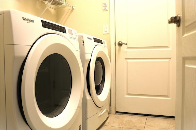 washroom featuring light tile patterned floors and washing machine and clothes dryer