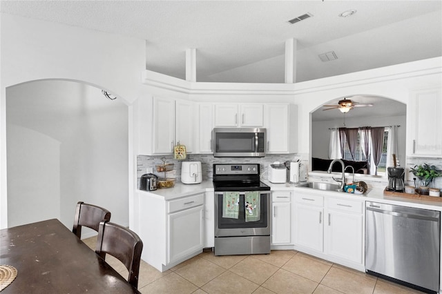 kitchen with backsplash, white cabinets, sink, ceiling fan, and appliances with stainless steel finishes